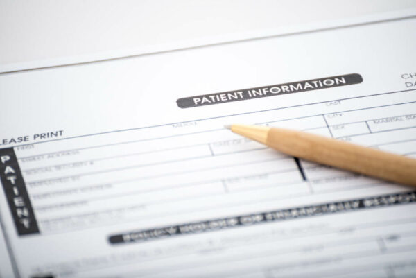Patient information form with a pencil on top of it